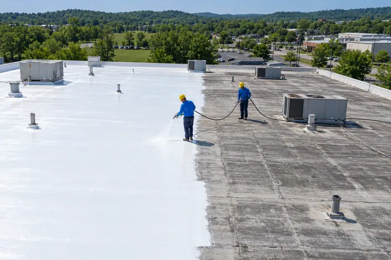 Aerial view of silicone coating going onto a low-slope commercial roof